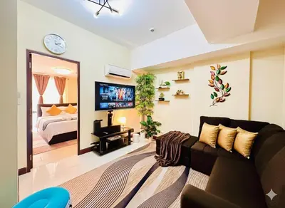 a living room with a couch and a bed at AdahkuMaya Luxury Suites in Manila