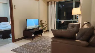 a living room with a couch and a television at Casa Antonio at 8L Two Palm Tree Beside NAIA3 in Manila