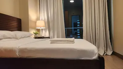 a bedroom with a large bed with a window at Casa Antonio at 8L Two Palm Tree Beside NAIA3 in Manila