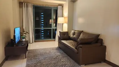 a living room with a couch and a television at Casa Antonio at 8L Two Palm Tree Beside NAIA3 in Manila
