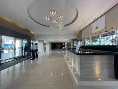 a lobby with a chandelier and people standing in a building at Joyce Condo unit Sea Residences in Manila