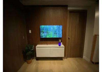 a living room with a tv on a wall at Cozy Urban Staycation Condo Unit in Manila