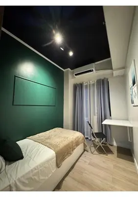 a bedroom with a bed and a green wall at Cozy Urban Staycation Condo Unit in Manila