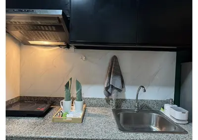 a kitchen counter with a sink and a microwave at Cozy Urban Staycation Condo Unit in Manila