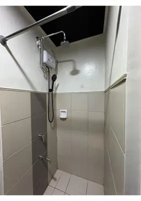 a shower in a bathroom with a shower head at Cozy Urban Staycation Condo Unit in Manila