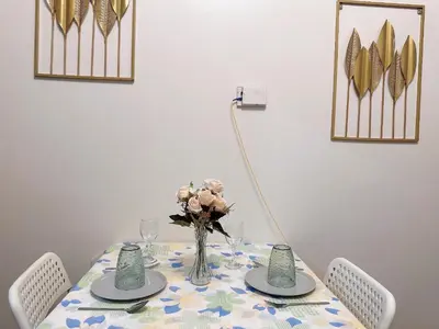 a dining room table with a vase of flowers on it at Air Residences 3 by AG in Manila