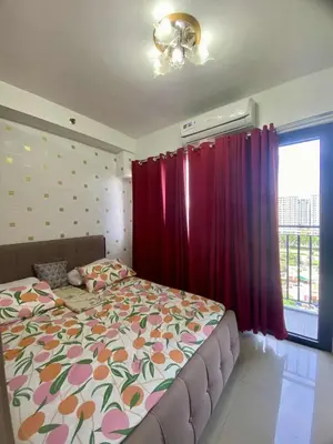 a bedroom with a bed and a red curtain at LiCa Place 2 in Manila