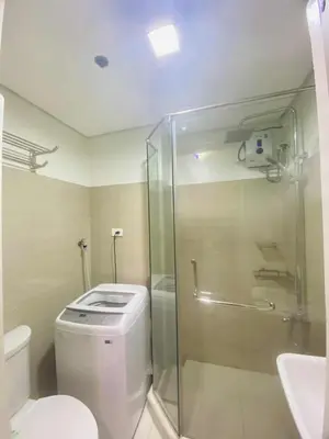 a bathroom with a shower and a toilet and a sink at LiCa Place 2 in Manila