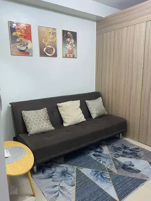 a black couch in a living room with a table at LiCa Place 2 in Manila