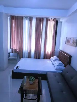 a bedroom with a large bed and a couch at Eurica transient Inn in Manila