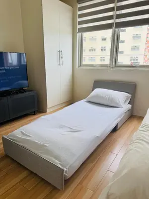 a bedroom with a bed and a flat screen tv at Casa Chloe at Holland Park in Biñan