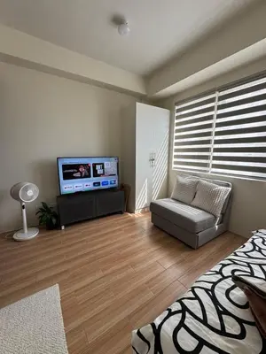 a living room with a flat screen tv and a couch at Casa Chloe at Holland Park in Biñan