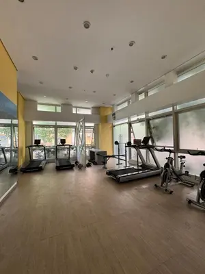 a gym with treadmills and ellipticals in a building at Casa Chloe at Holland Park in Biñan