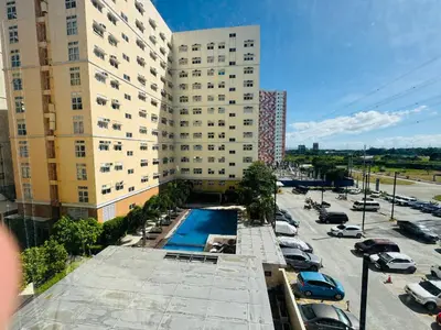 a building with a pool in front of a parking lot at Casa Chloe at Holland Park in Biñan