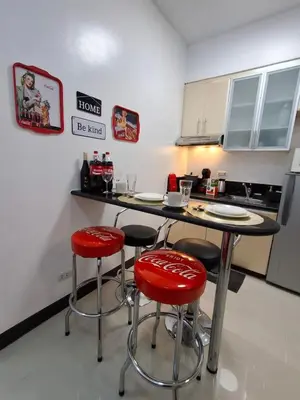 a kitchen with red stools and a table in a kitchen at CocaCola Studio Unit McKinley in Manila