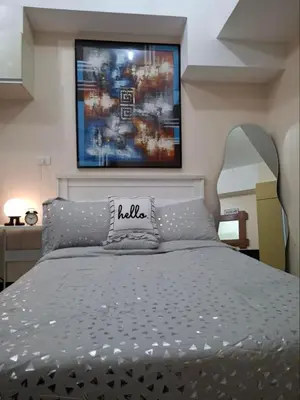 a bedroom with a bed with a painting on the wall at Cozy Studio Unit McKinley Hill in Manila