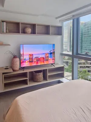 a bedroom with a flat screen tv on a entertainment center at Modern 1BR BGC Uptown View in Manila