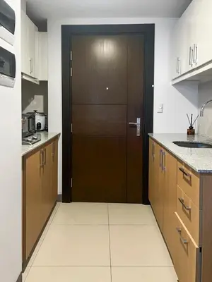 a kitchen with a brown door in the middle at Modern 1BR BGC Uptown View in Manila