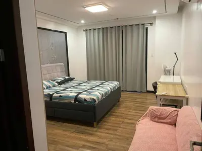 a bedroom with a bed and a table and a desk at \u51b0\u5c9b\u5047\u65e5\u516c\u5bd3 in Manila