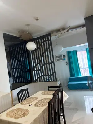 a dining room with a table and chairs and a bed at UrbanhavenCozyFamilybedroom in Manila
