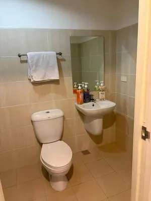 a bathroom with a toilet and a sink at UrbanhavenCozyFamilybedroom in Manila