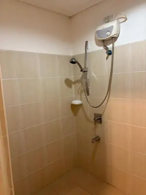 a shower with a shower head in a bathroom at UrbanhavenCozyFamilybedroom in Manila