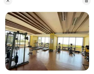 a gym with several treadmills and machines in a room at UrbanhavenCozyFamilybedroom in Manila