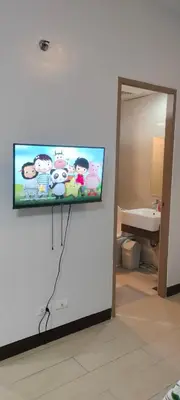 a flat screen tv on a wall in a bathroom at Rqui Rooms Near Airport in Manila