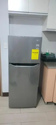 a refrigerator in a kitchen with a yellow sign on it at Rqui Rooms Near Airport in Manila