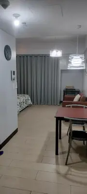 a living room with a couch and a table and a bed at Rqui Rooms Near Airport in Manila