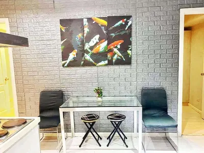 a kitchen with two chairs and a table and paintings at St Tropez PH 07 in Manila