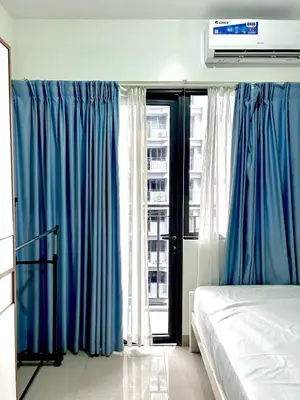 a bedroom with blue curtains and a bed and a window at Stylish 1BR Condo at Shore Netflix & Chill-Pool View in Manila