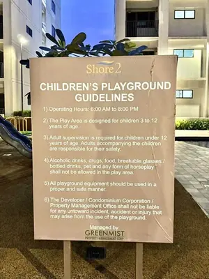 a sign in front of a building at Stylish 1BR Condo at Shore Netflix & Chill-Pool View in Manila