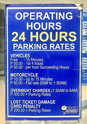 a sign for operating hours and hours parking rates at Stylish 1BR Condo at Shore Netflix & Chill-Pool View in Manila