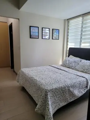 a bedroom with a bed with a black and white comforter at BGC Uptown Park Suites Tower 1 - 2 Bedroom and 2 Bath Condo in Manila