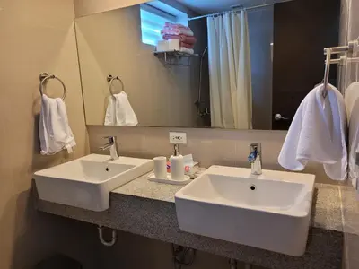 a bathroom with two white sinks and a mirror at BGC Uptown Park Suites Tower 1 - 2 Bedroom and 2 Bath Condo in Manila