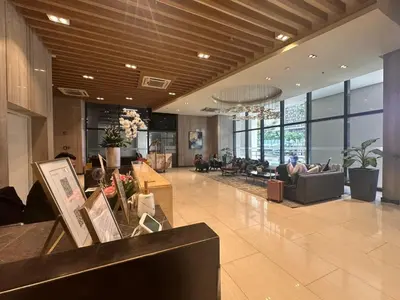 a lobby with a couch and chairs in a building at BGC Uptown Park Suites Tower 1 - 2 Bedroom and 2 Bath Condo in Manila