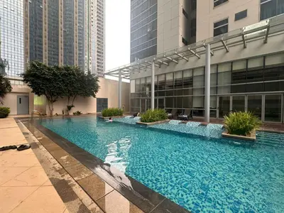 a large swimming pool in a building with tall buildings at BGC Uptown Park Suites Tower 1 - 2 Bedroom and 2 Bath Condo in Manila