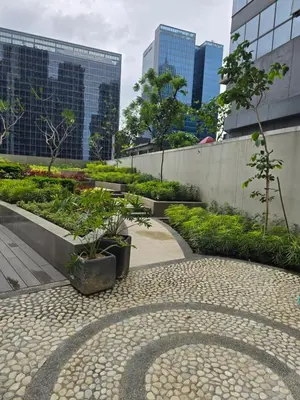 a garden in a city with tall buildings at BGC Uptown Park Suites Tower 1 - 2 Bedroom and 2 Bath Condo in Manila