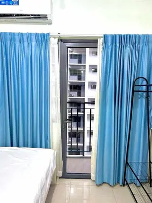 a bedroom with blue curtains and a bed and a window at 1 Bedroom Condo at Shore 2 Near Airport with Balcony & Pool View in Manila