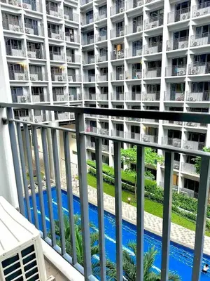 a balcony of a apartment building with a swimming pool at 1 Bedroom Condo at Shore 2 Near Airport with Balcony & Pool View in Manila