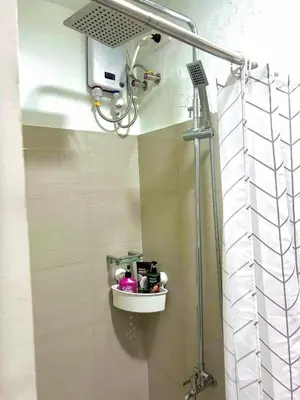 a shower in a bathroom with a shelf on the wall at 1 Bedroom Condo at Shore 2 Near Airport with Balcony & Pool View in Manila