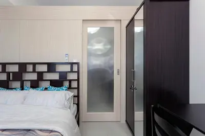 a bedroom with a bed and a sliding glass door at Cozy 1BR Condo at Jazz Residences in Manila