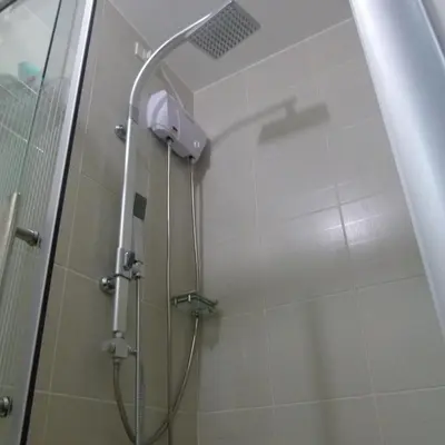 a shower with a glass door in a bathroom at Cozy 1BR Condo at Jazz Residences in Manila