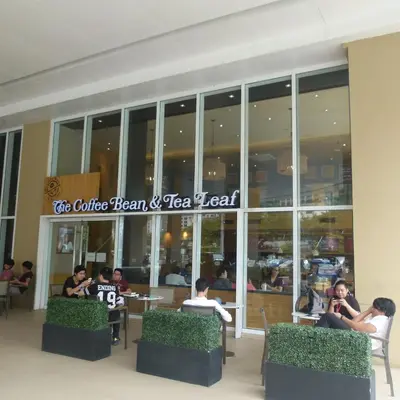 a group of people sitting outside of a restaurant at Cozy 1BR Condo at Jazz Residences in Manila