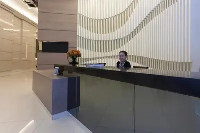 a man sitting at a desk in a lobby at Cozy 1BR Condo at Jazz Residences in Manila