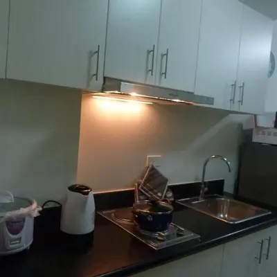 a kitchen counter top with a sink and a sink at Cozy 1BR Condo at Jazz Residences in Manila