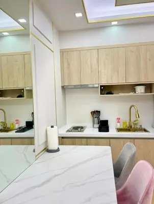 a kitchen with a white table and chairs and cabinets at Chic BGC Stay - Hotel Vibes in Manila