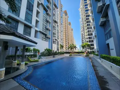 a swimming pool in the middle of a building with tall buildings at Chic BGC Stay - Hotel Vibes in Manila