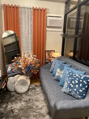 a living room with a couch with blue pillows at Elim Escape Staycation in Trece Martires